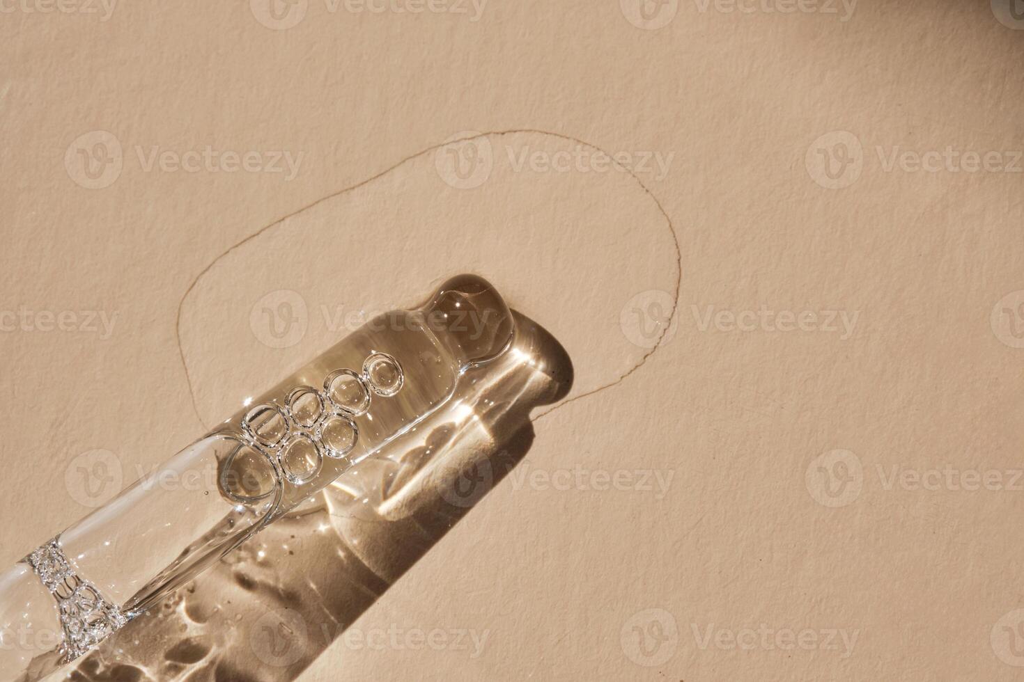 Pipette with serum on a beige background. photo