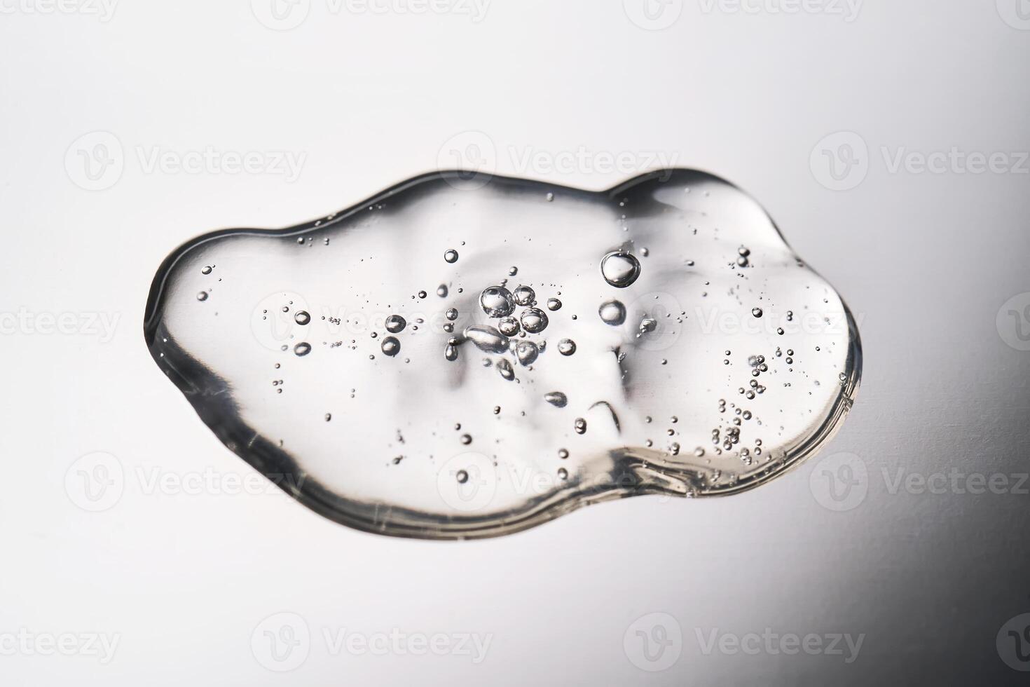 A smear of cosmetic gel close-up on a gray background. Appetizing texture with bubbles. photo