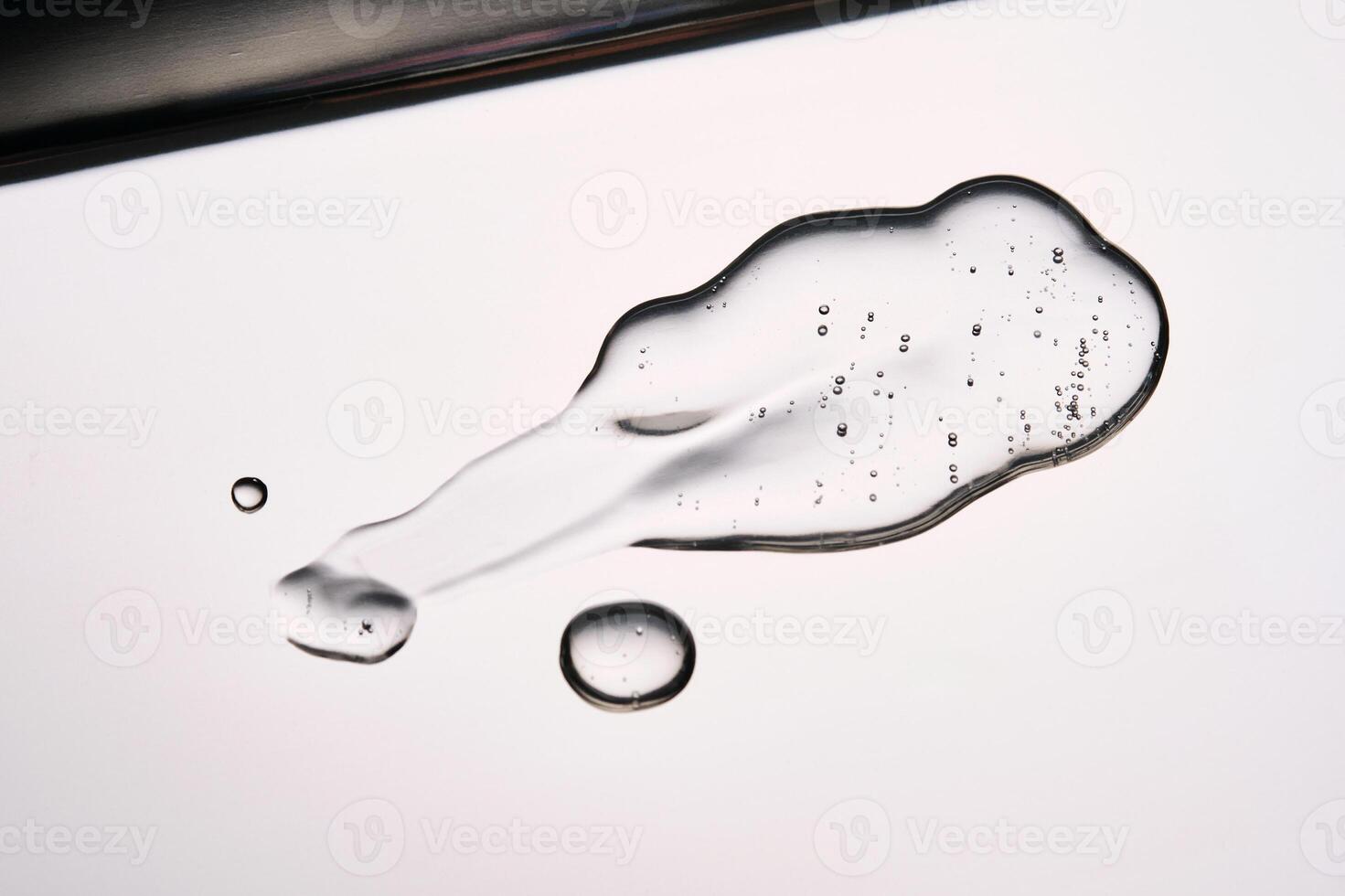 A smear of cosmetic gel close-up on a gray background. Appetizing texture with bubbles. photo