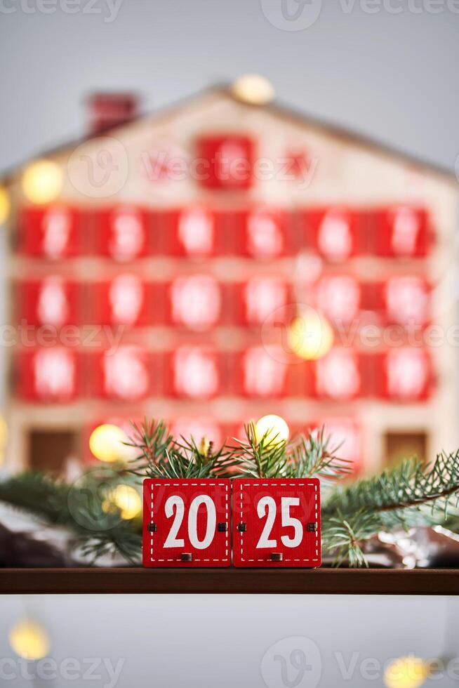 Christmas Advent calendar in the shape of a house with boxes making up the number 2025. photo