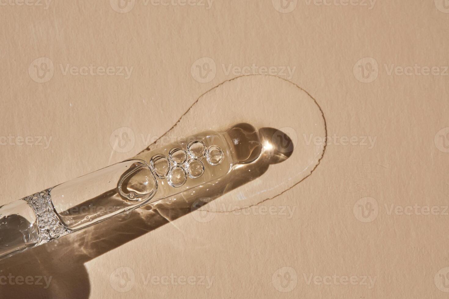 Pipette with serum on a beige background. photo