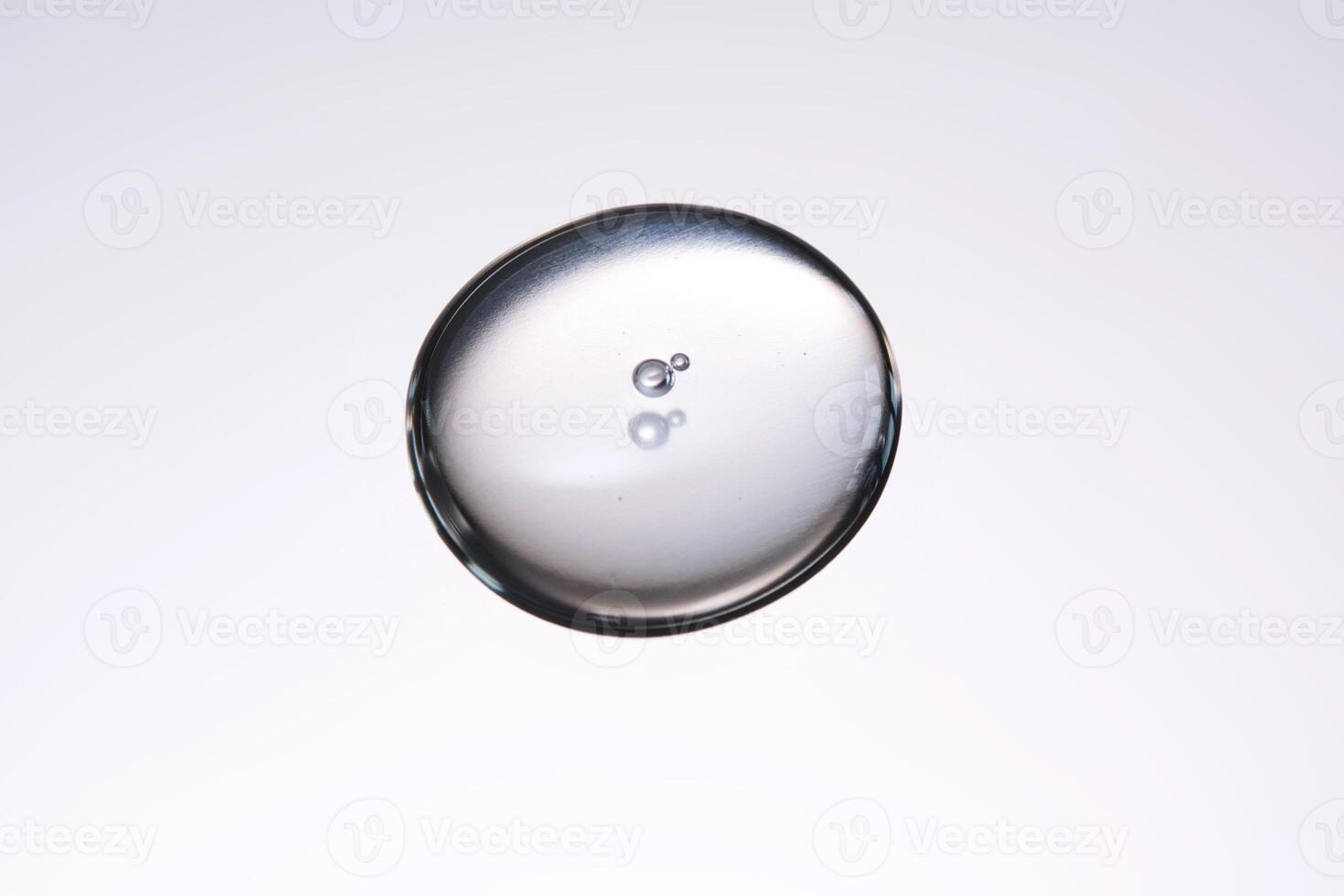 A smear of cosmetic gel close-up on a gray background. Appetizing texture with bubbles. photo