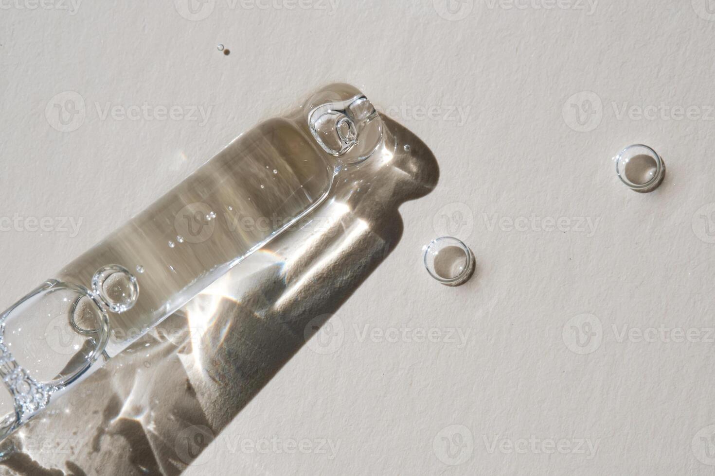 Pipette with serum on a beige background. photo