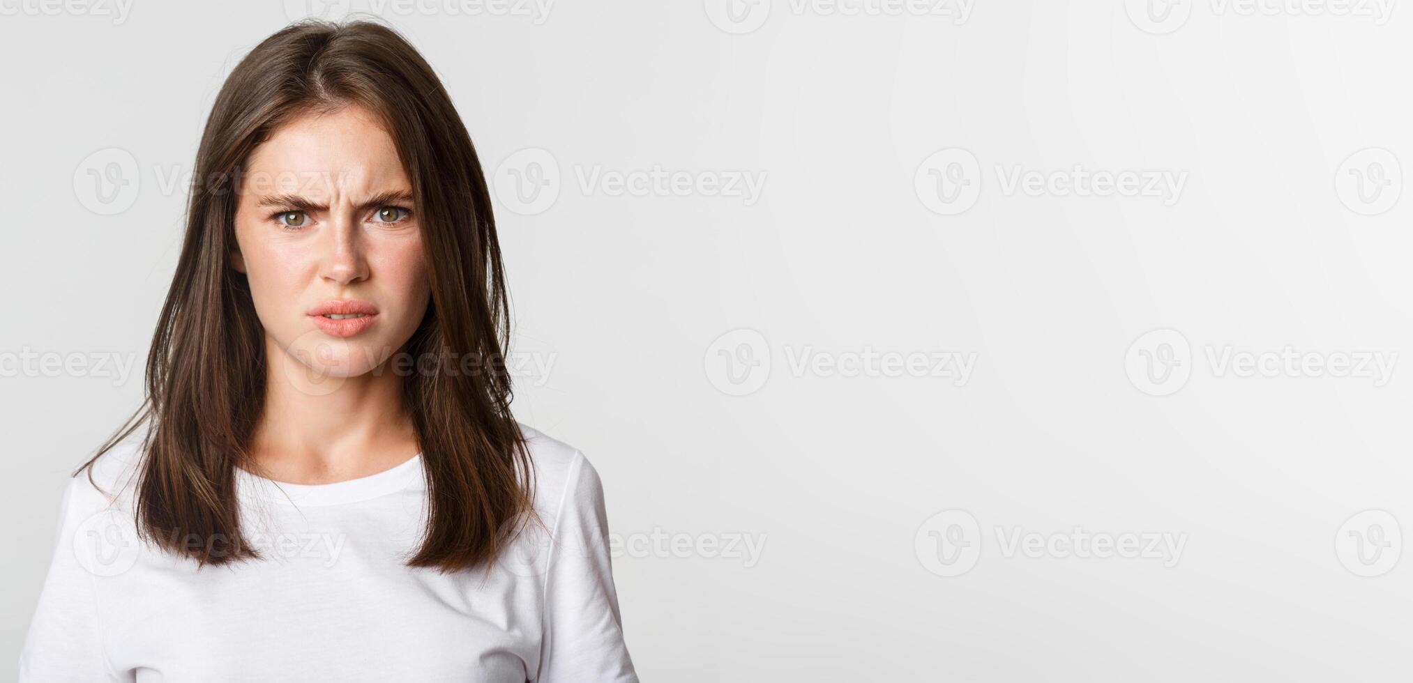 Close-up of skeptical and displeased attractive girl shaking head in rejection, frowning disappointed photo