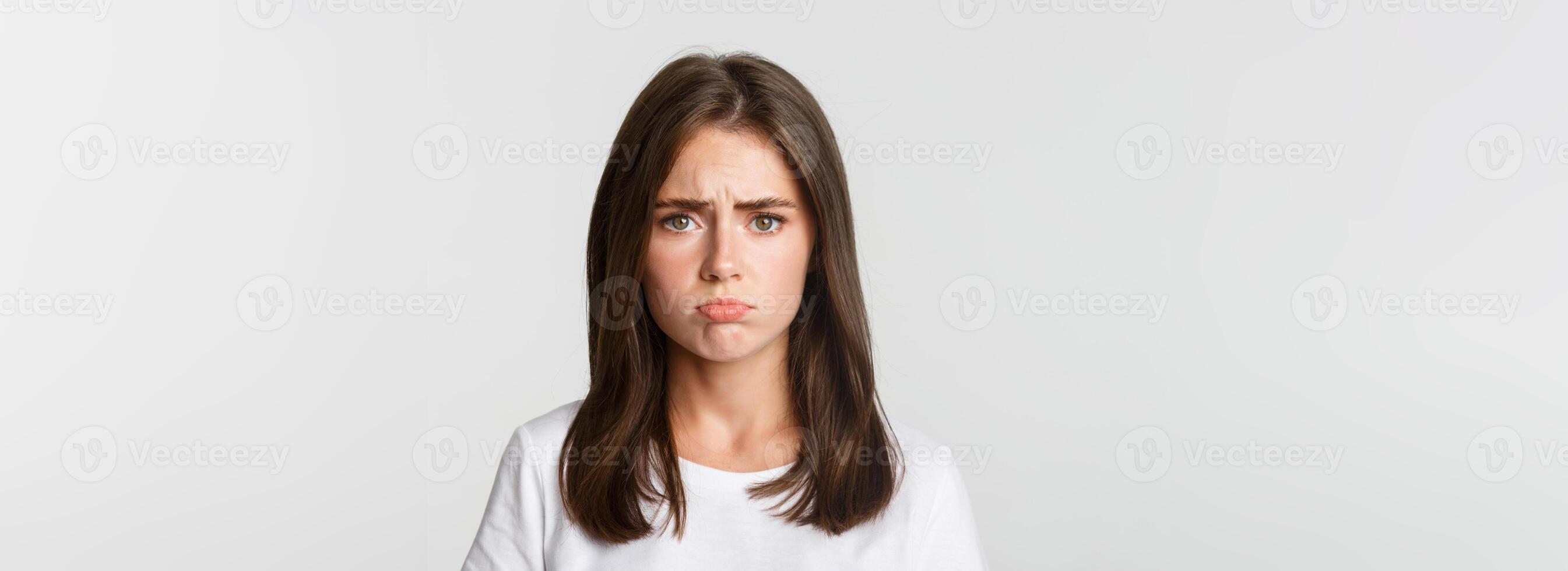 Close-up of sad brunette girl sulking and looking upset photo
