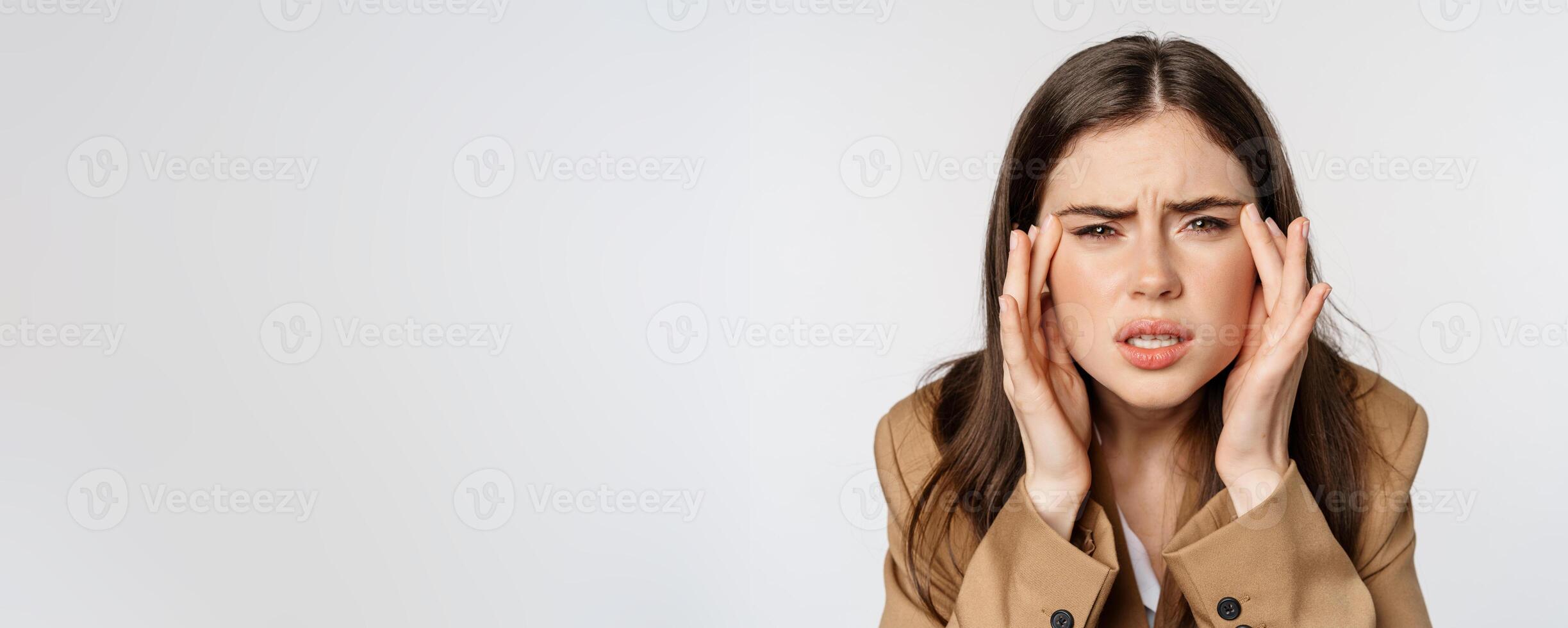 Close up portrait of business woman squinting and looking without glasses, cant see, bad sight without eyewear, standing over white background photo