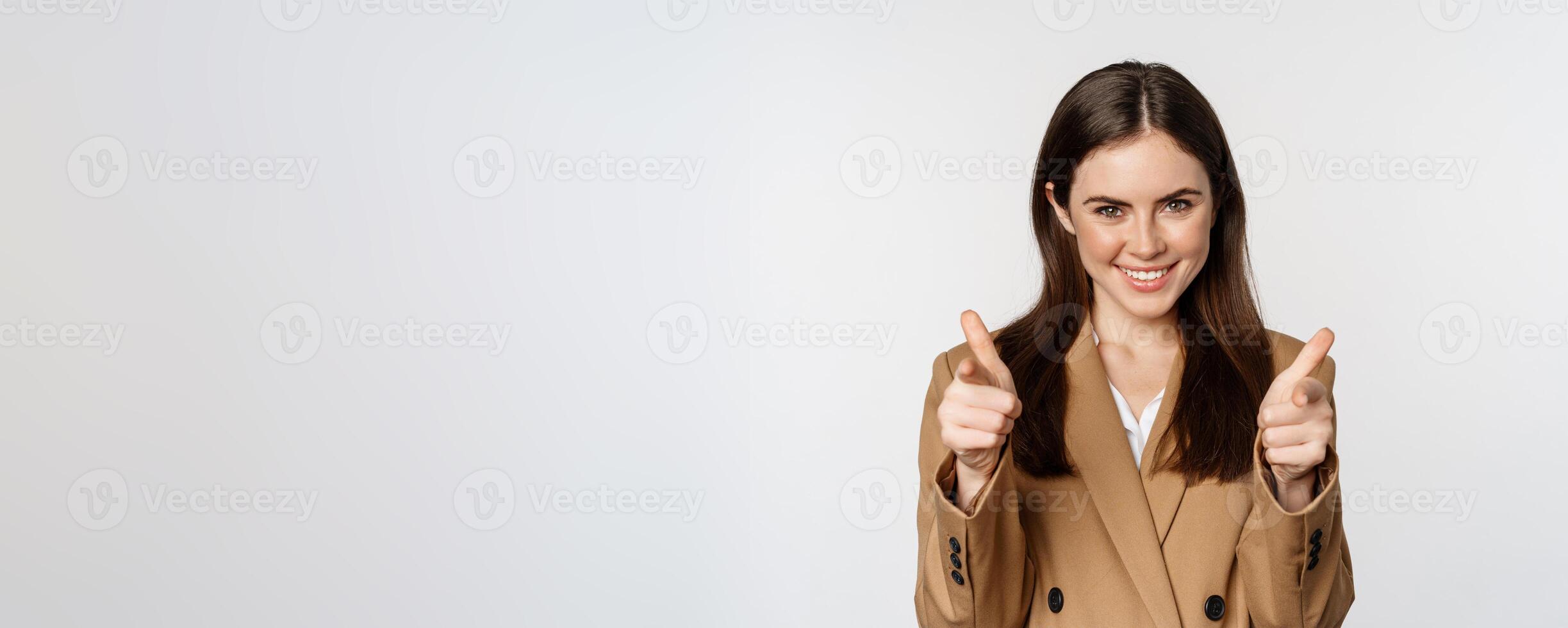 Enthusiastic businesswoman, corporate woman showing thumbs up and smiling, complimenting, recommending company, standing over white background photo