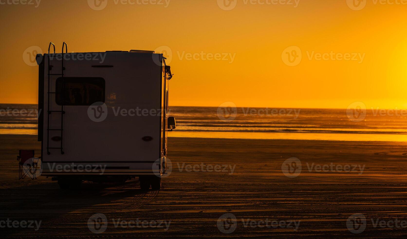 Relaxing Evening at the Beach With an RV Under a Vibrant Sunset photo