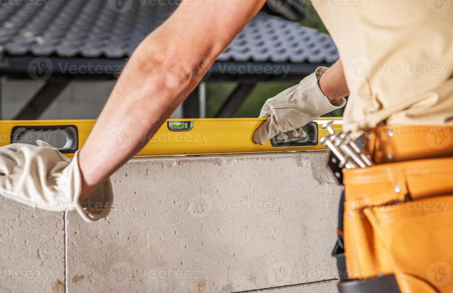 Construction Worker Using Level Tool on Block Wall at Job Site photo