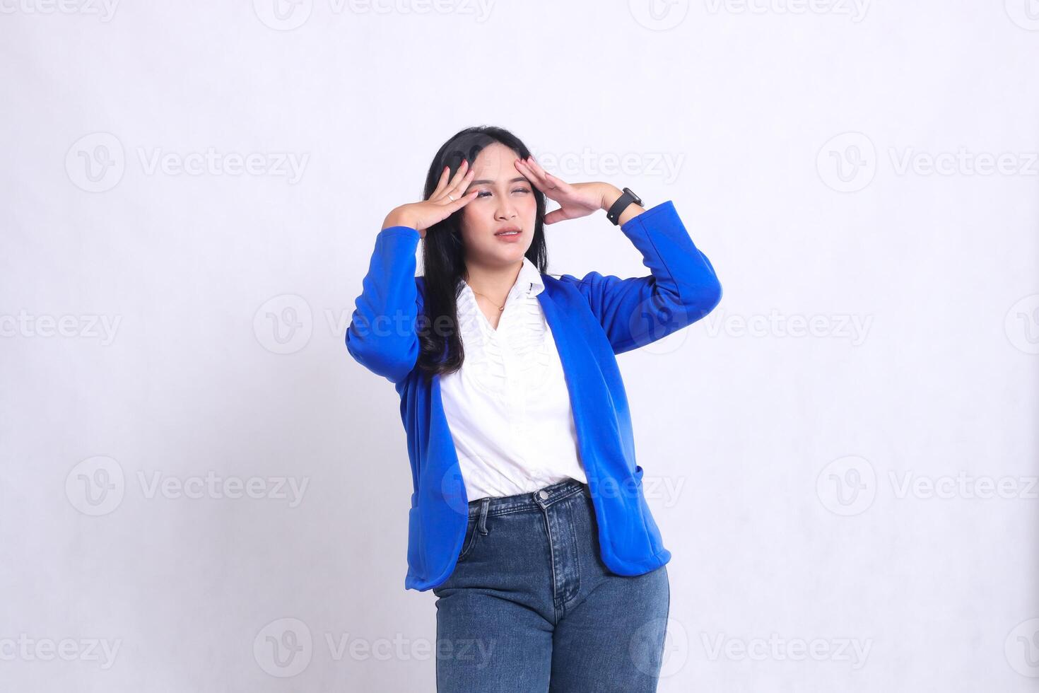 expression of beautiful mature office woman wearing blue formal suit standing candid pain dizzy both hands holding head. for company content, health, business, care, lifestyle photo