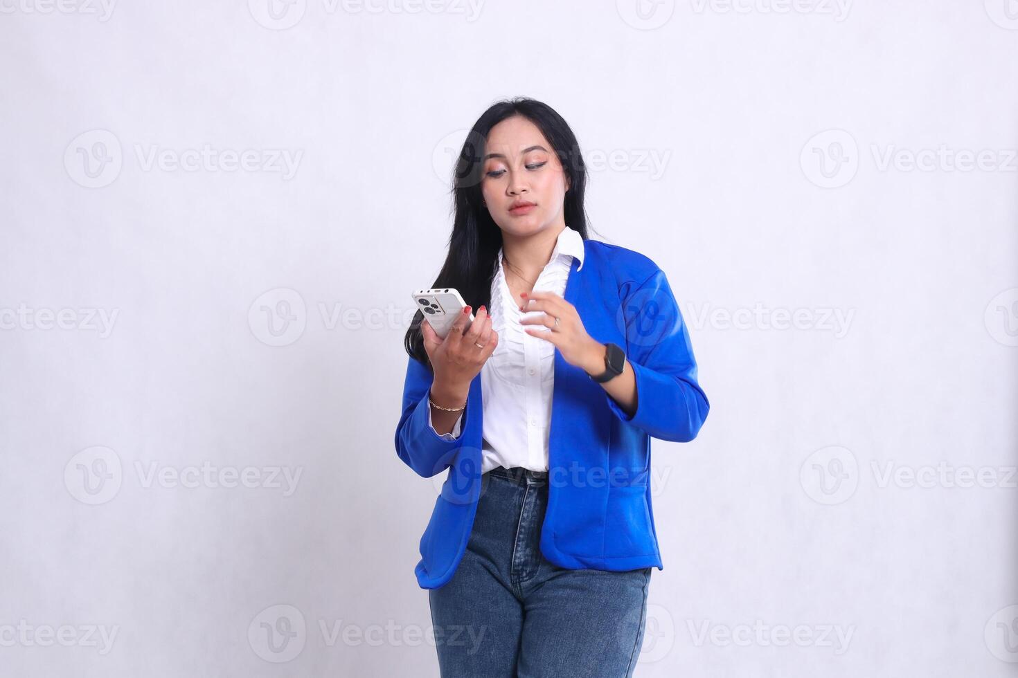 beautiful adult office woman wearing blue formal suit standing elegantly carrying smartphone mobile phone isolated white background. for technology, lifestyle, music, entertainment content photo