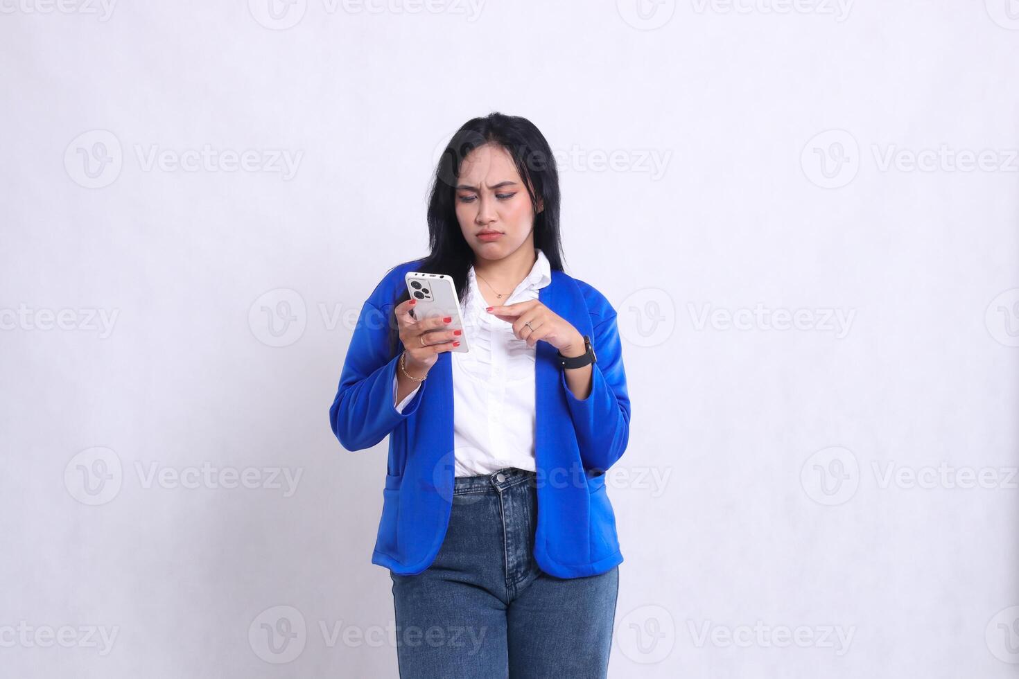 beautiful mature office woman wearing blue formal suit standing pouting candid operating smartphone while touching cellphone screen. for technology content, lifestyle, mobile transactions photo