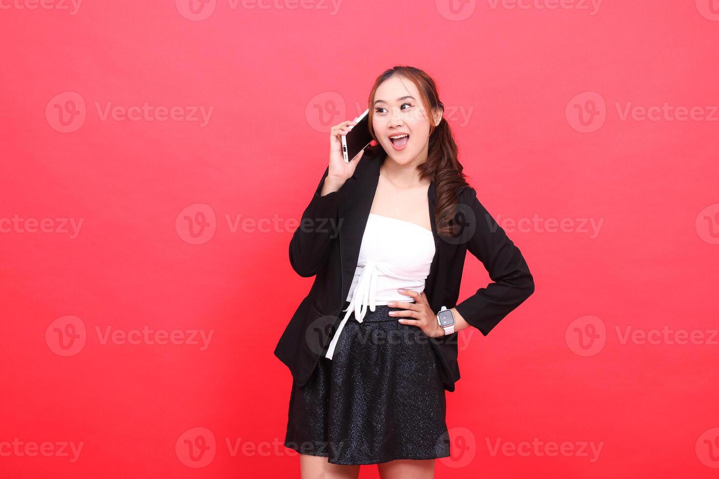 gesture of young indonesia career cheerful candid woman wearing black formal suit while calling people via smartphone, for technology, business, advertising, financial content photo