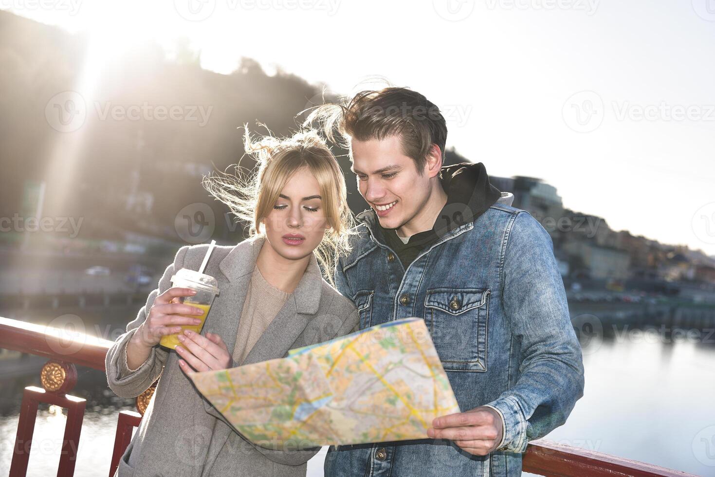 Man holding a map and look on a girl. Beautiful girl with juice photo