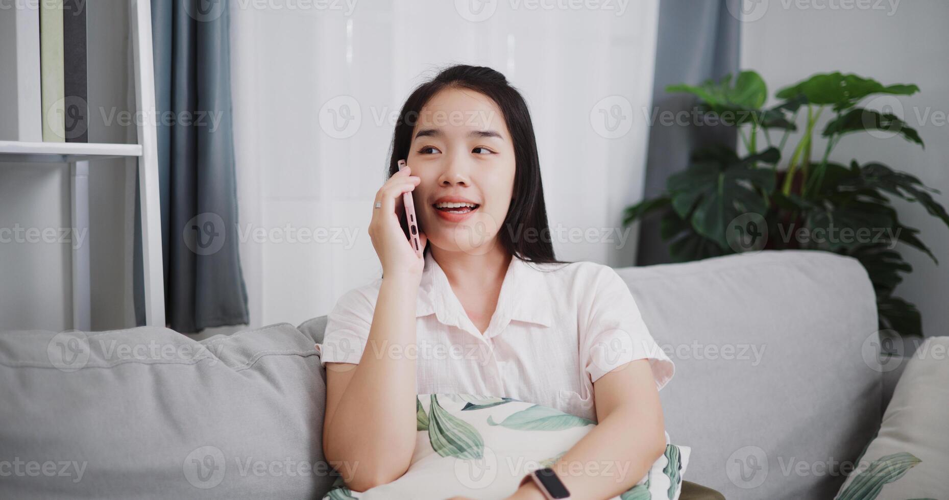 Portrait of Carefree young woman talking with her friend on cell phone on sofa at home ,Lifestyle with device technology, talking and smile with happy photo