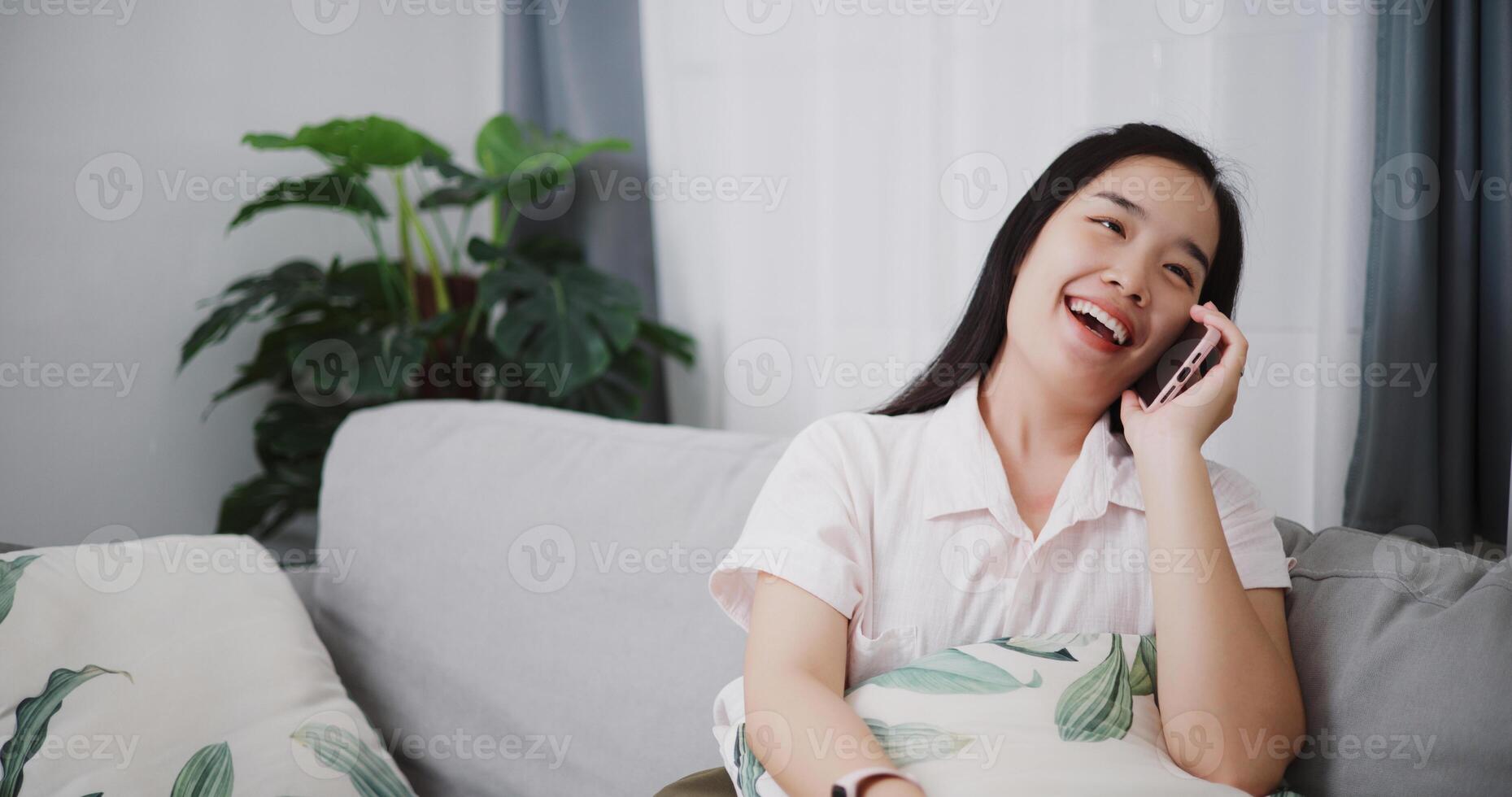 Portrait of Carefree young woman talking with her friend on cell phone on sofa at home ,Lifestyle with device technology, talking and smile with happy photo
