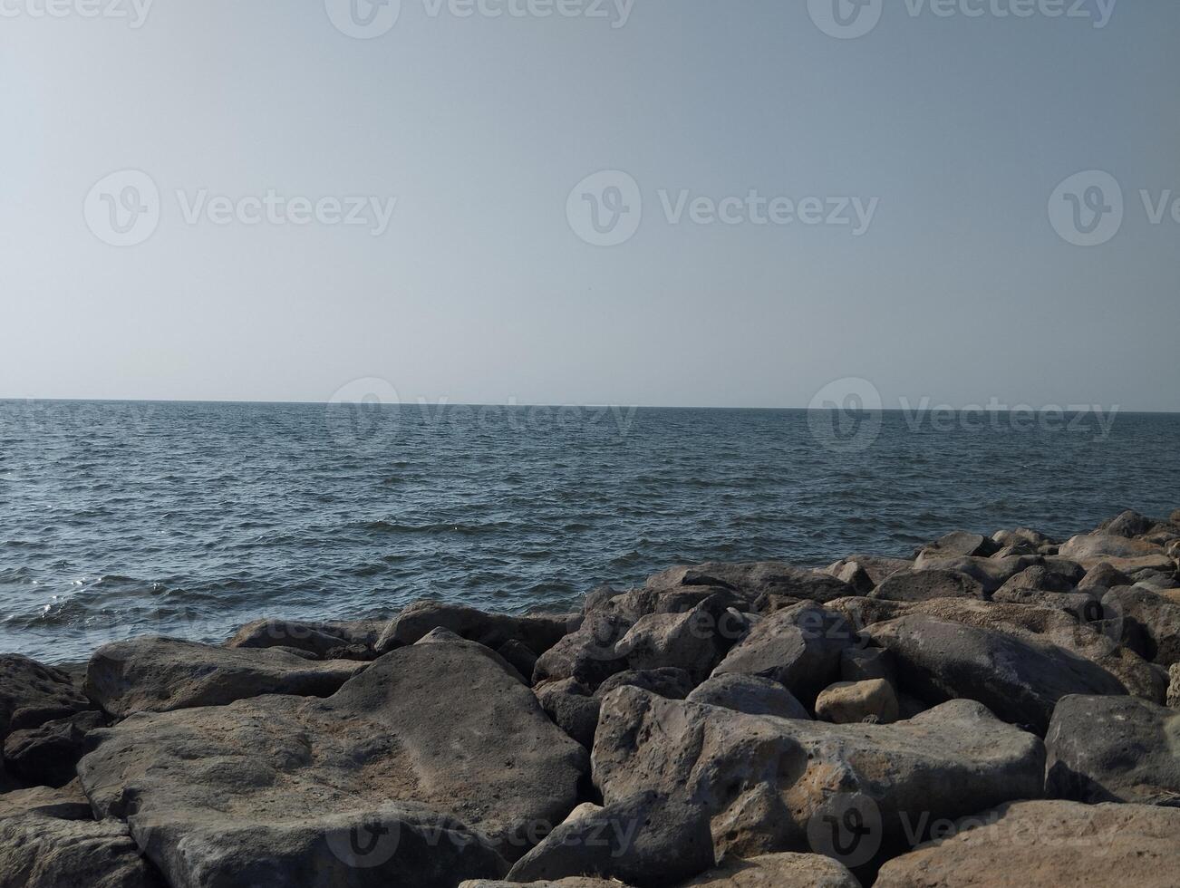 a view of the ocean from a rocky shoreline photo