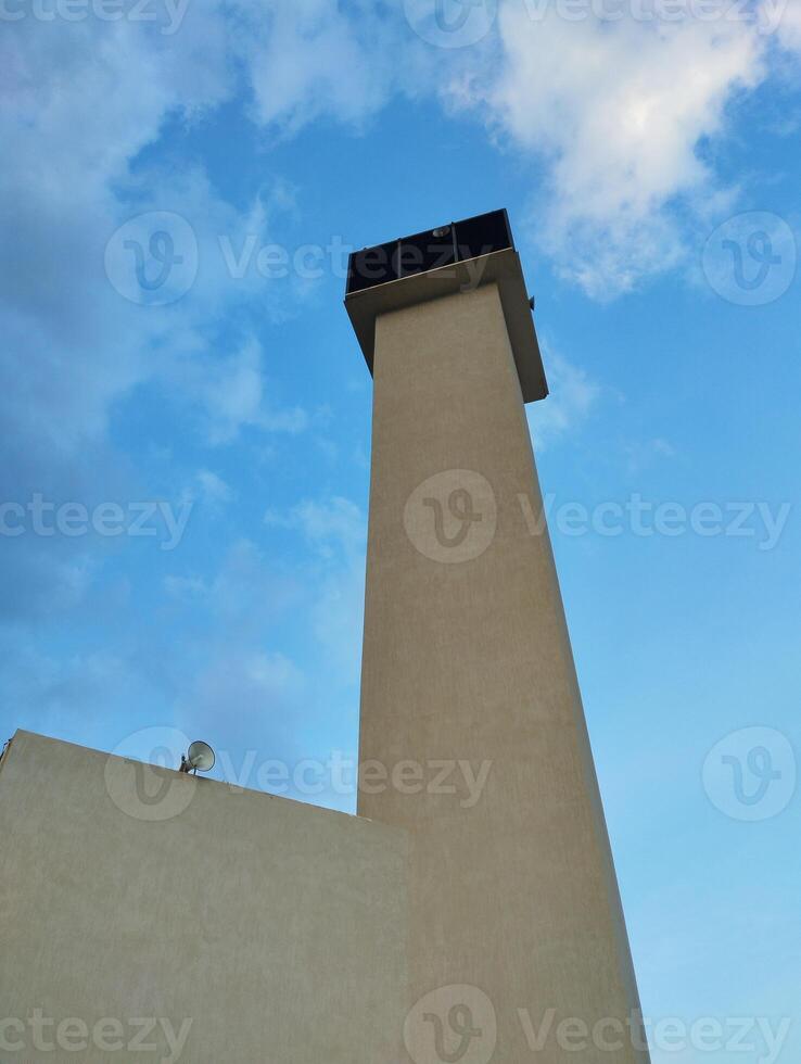 a mosque with a tall tower and a blue sky photo