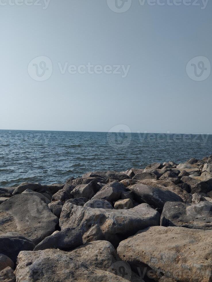 a rocky shoreline with a body of water in the background photo