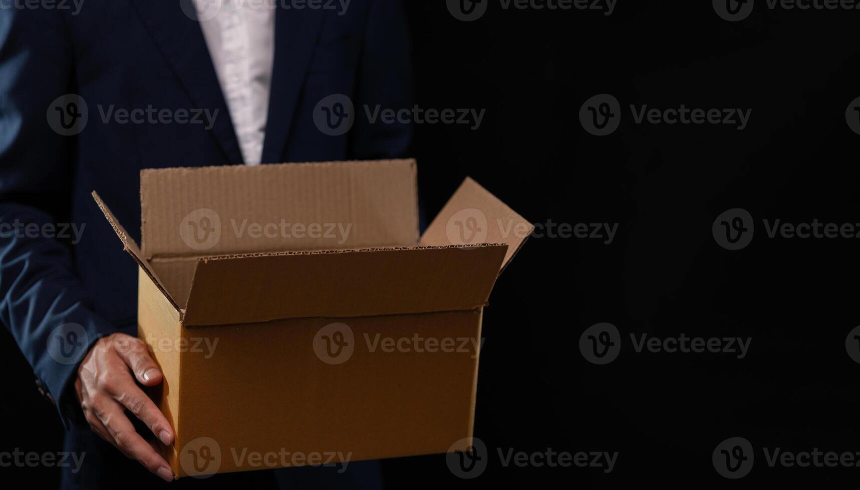 A man in a suit holding a cardboard box photo