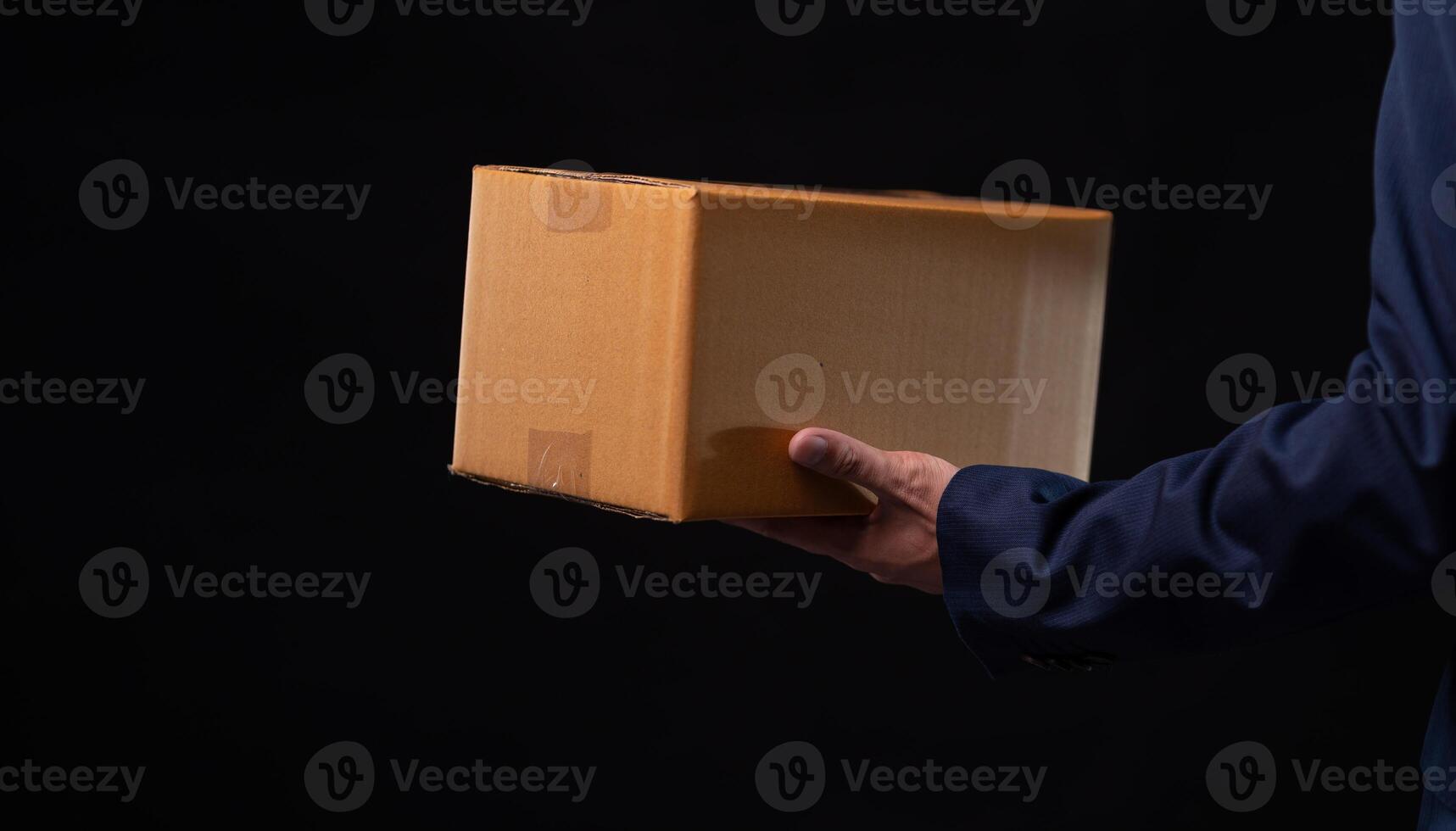 A man in a suit holding a cardboard box photo