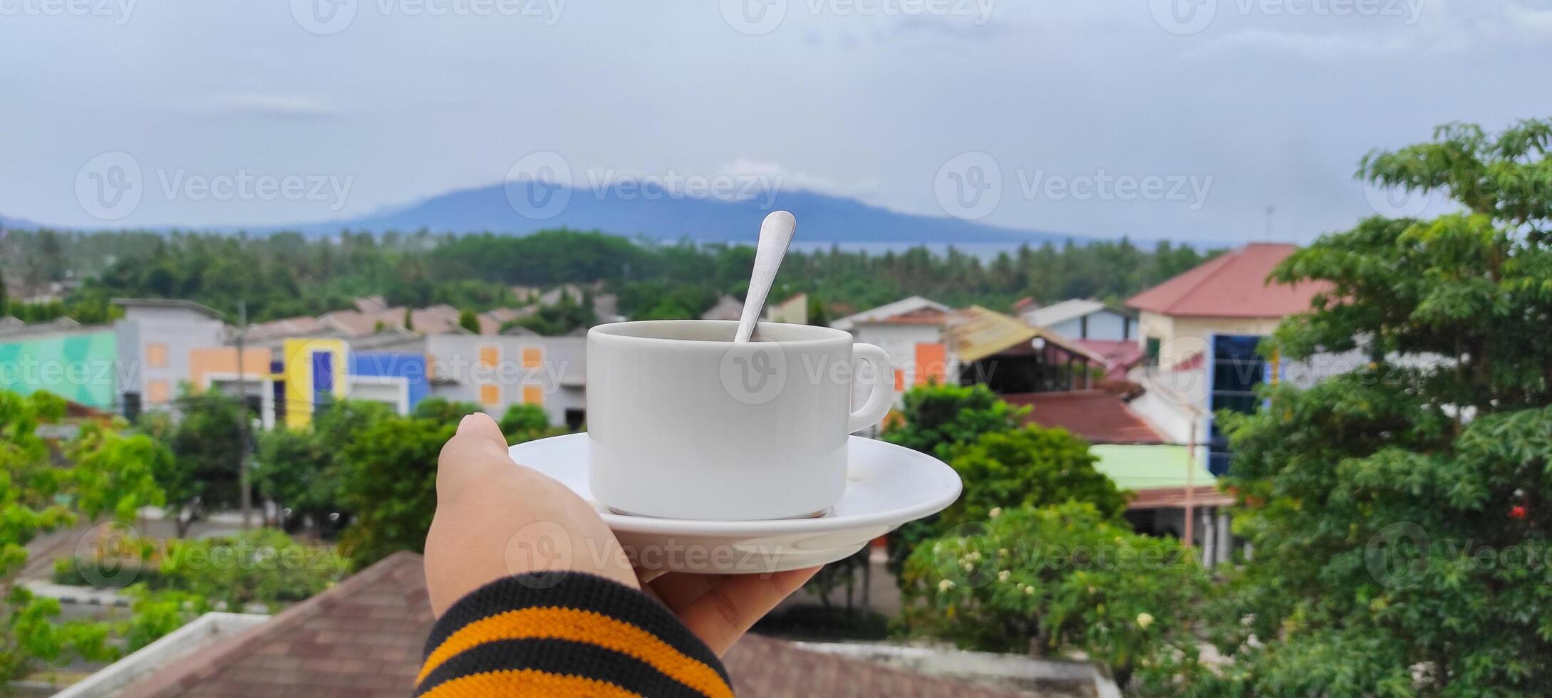 Women hand hold white cup with scenic background. photo