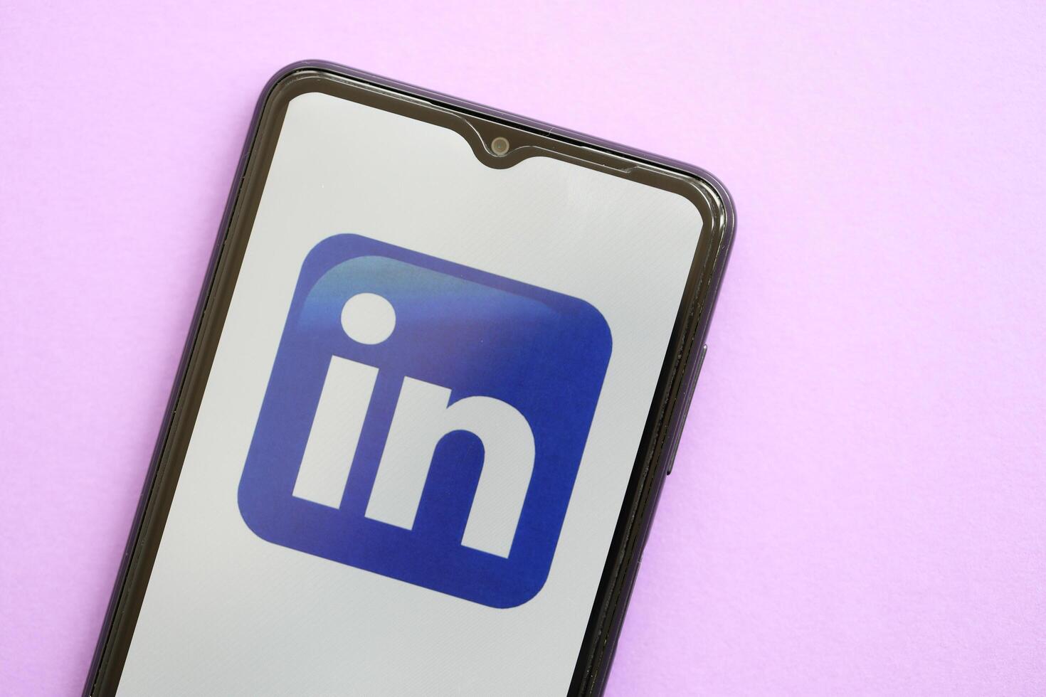 KYIV, UKRAINE - APRIL 1, 2024 LinkedIn icon on smartphone screen on purple table photo