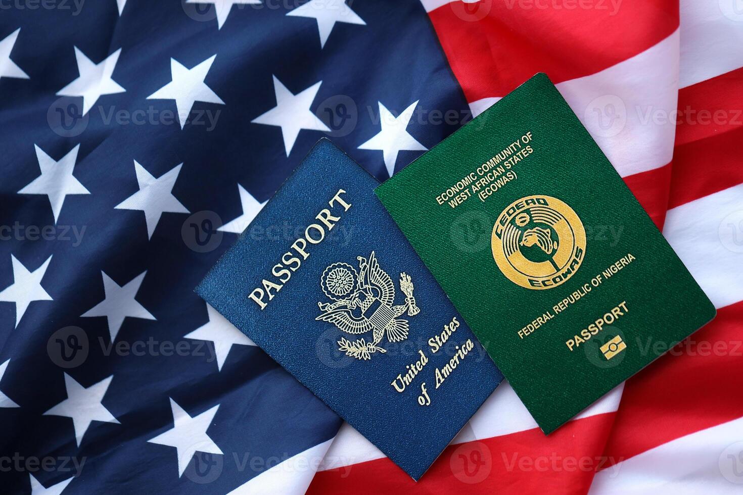 Passport of Nigeria with US Passport on United States of America folded flag photo