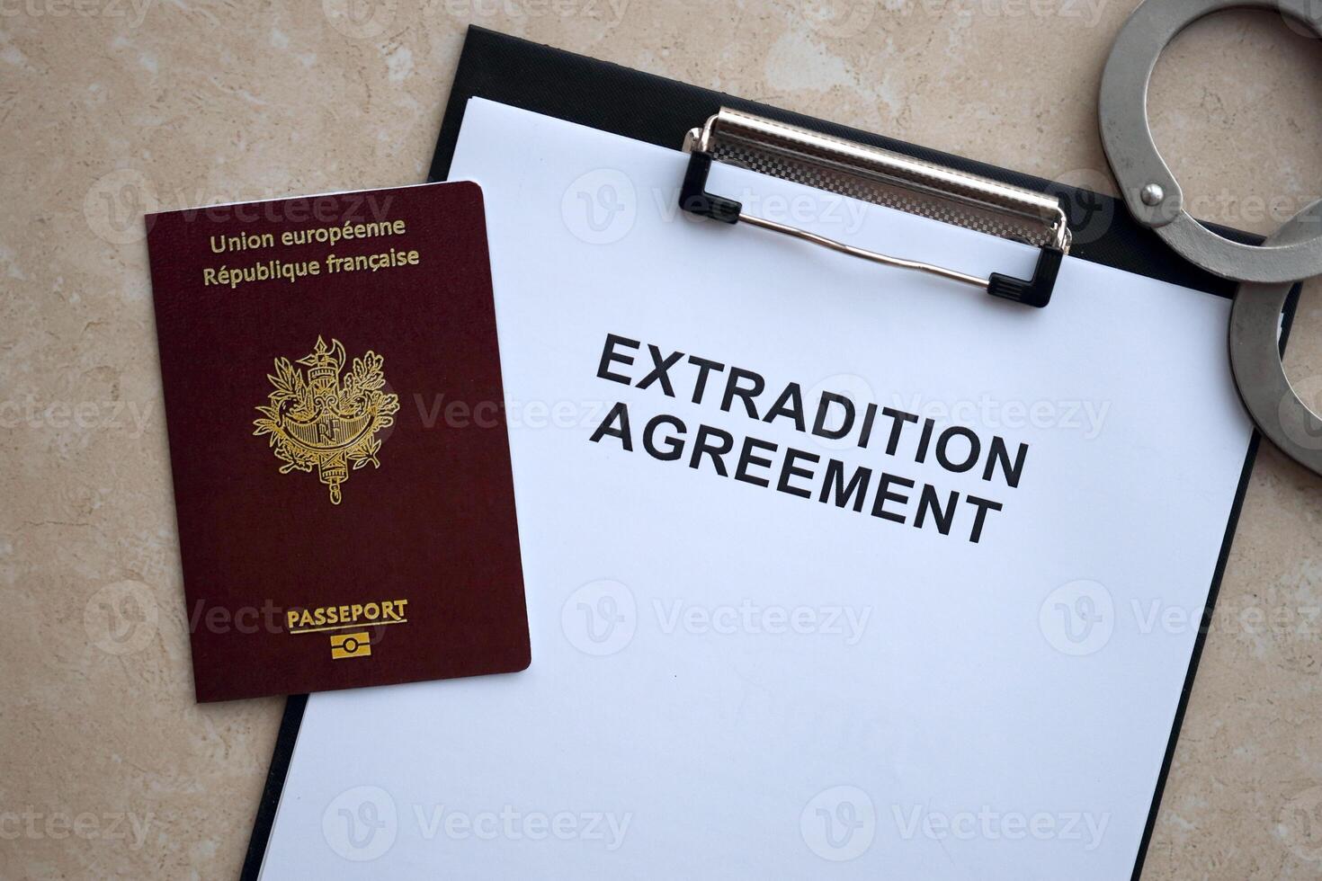 Passport of France and Extradition Agreement with handcuffs on table photo