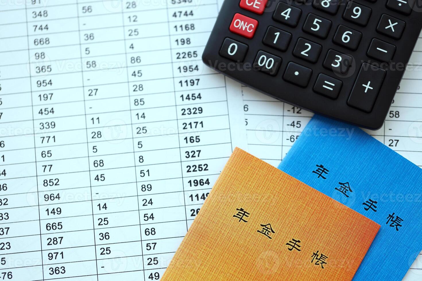 Japanese pension insurance booklets on table with calculator on table photo