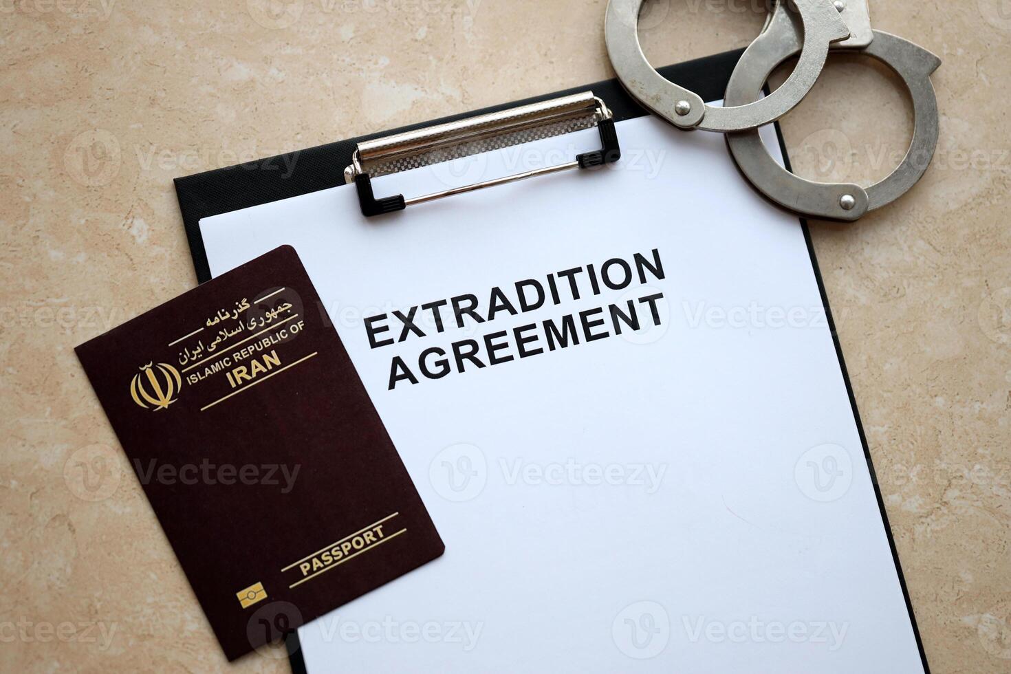 Passport of Iran and Extradition Agreement with handcuffs on table photo