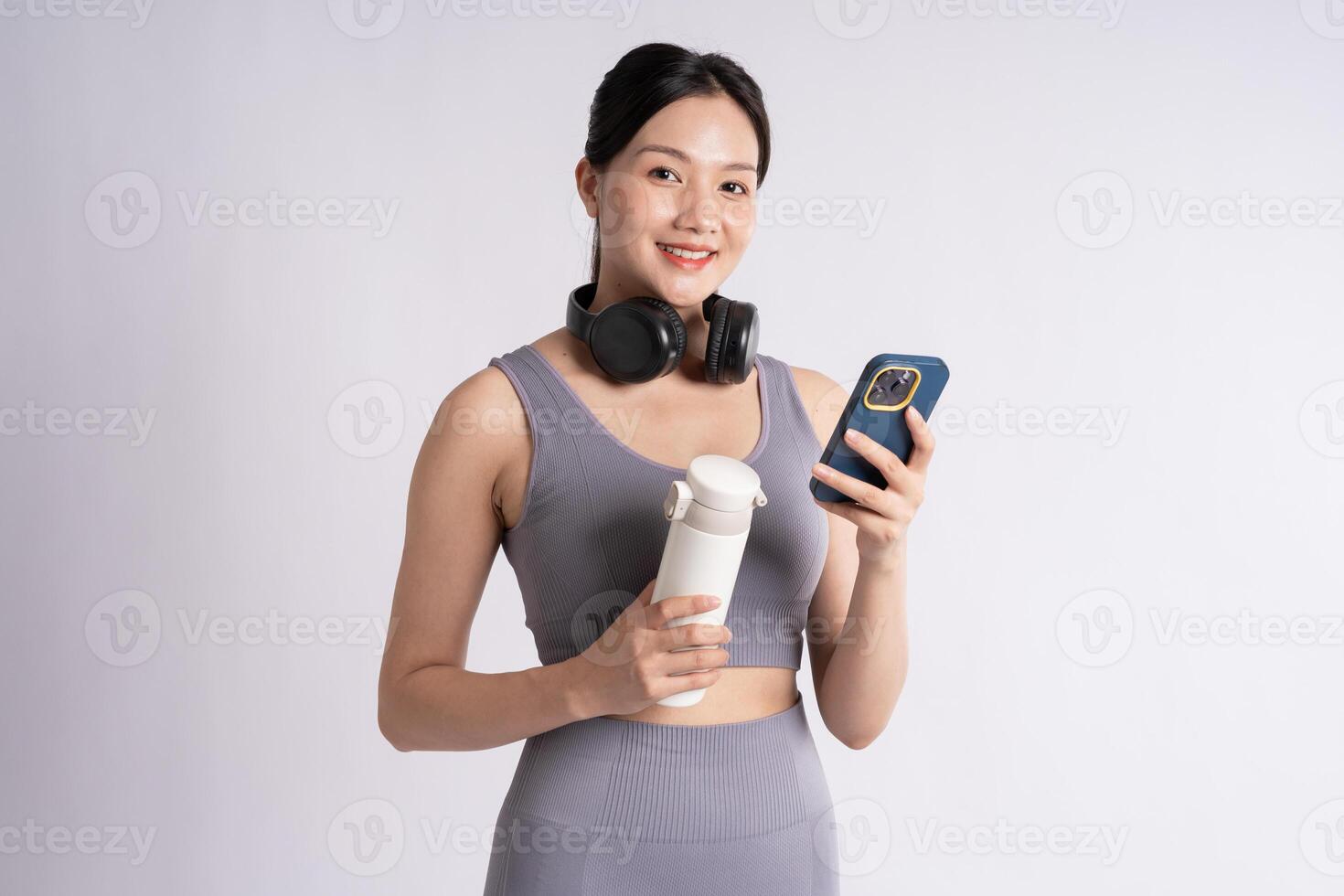 Portrait of Asian woman wearing sportswear, posing on white background photo