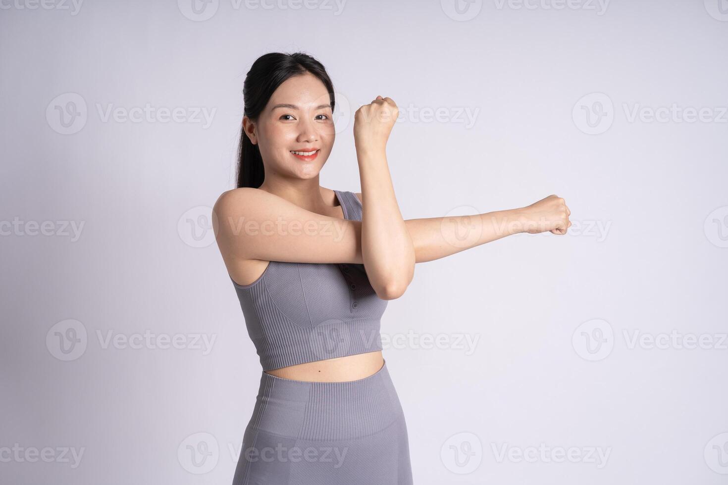 Portrait of Asian woman wearing sportswear, posing on white background photo
