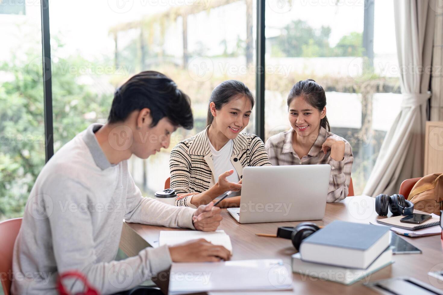 Group of Student Collaboration on a Project in a Modern Study Space with Laptops and Books photo
