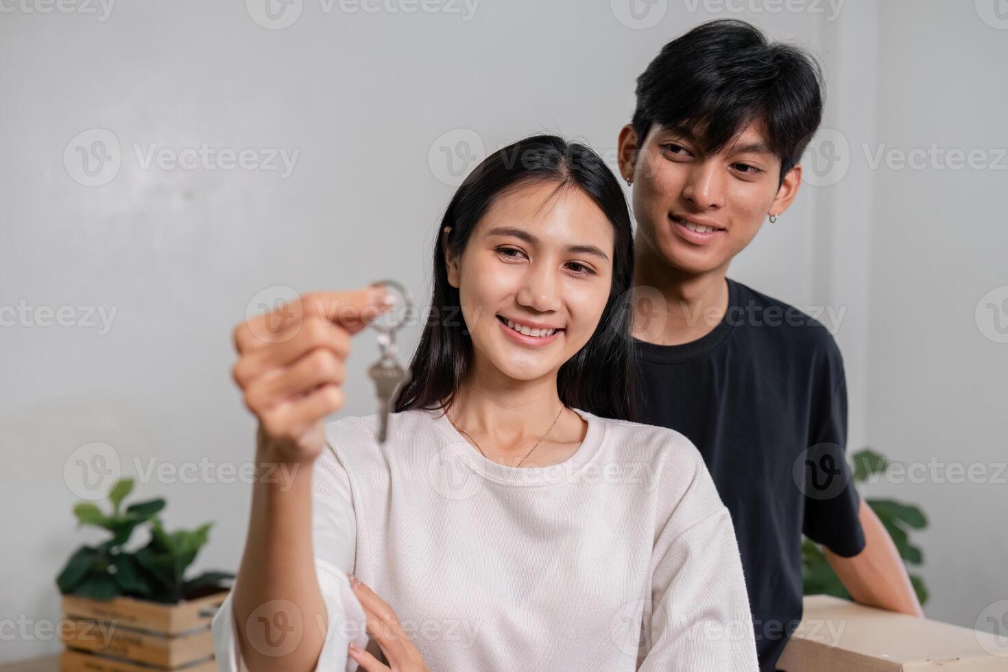 Happy Couple Holding Keys to New Home While Moving In Excited Young Adults Relocating to Modern House photo