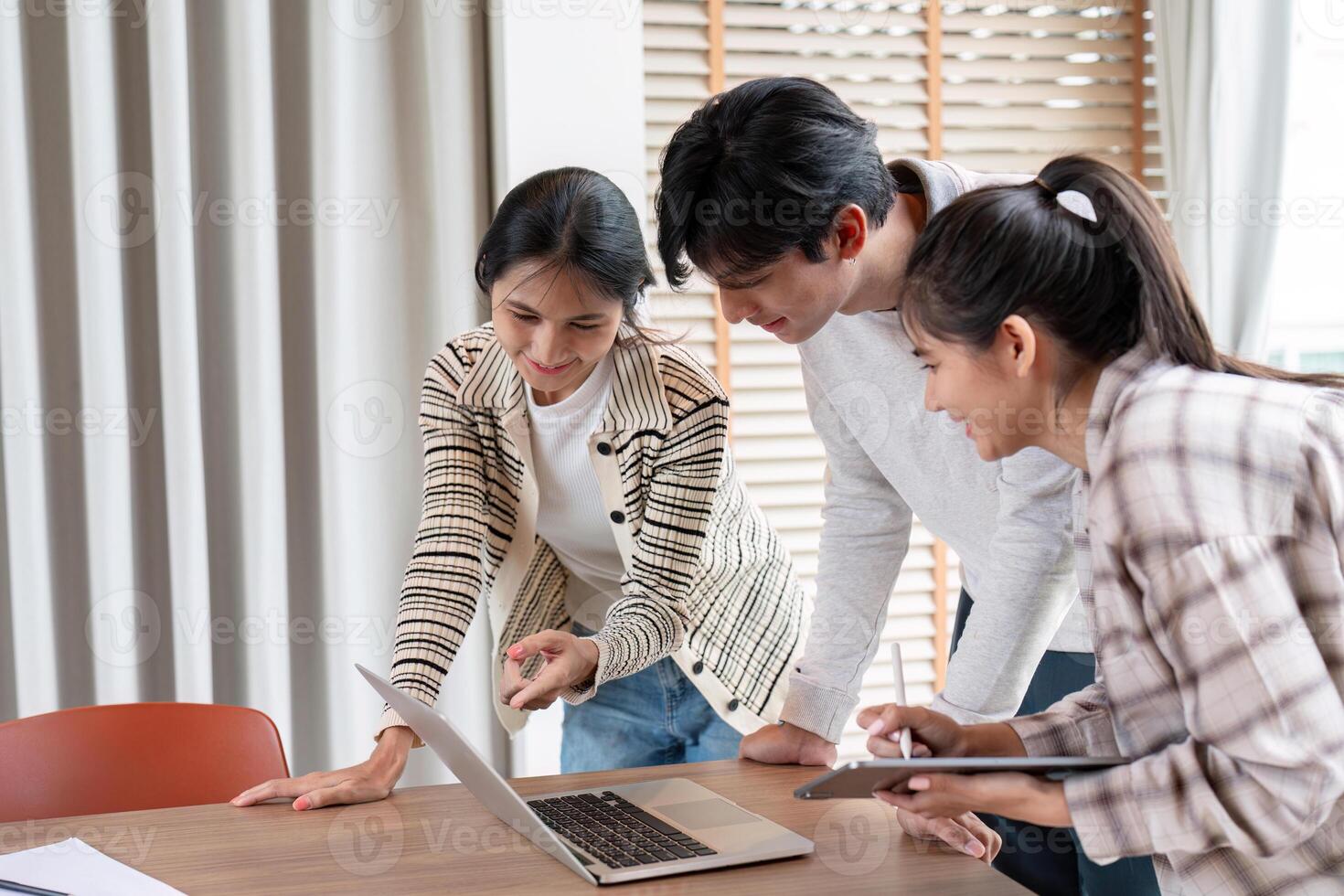 Group of Diverse Student Collaboration on a Project Using a Laptop and Tablet in a Modern Classroom Setting photo