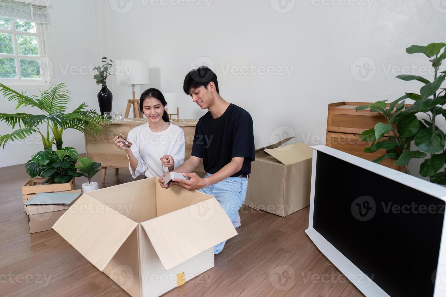 Young Couple Unpacking Boxes in New Home. Moving Day, New Beginnings, and Fresh Start in Modern Living Space photo