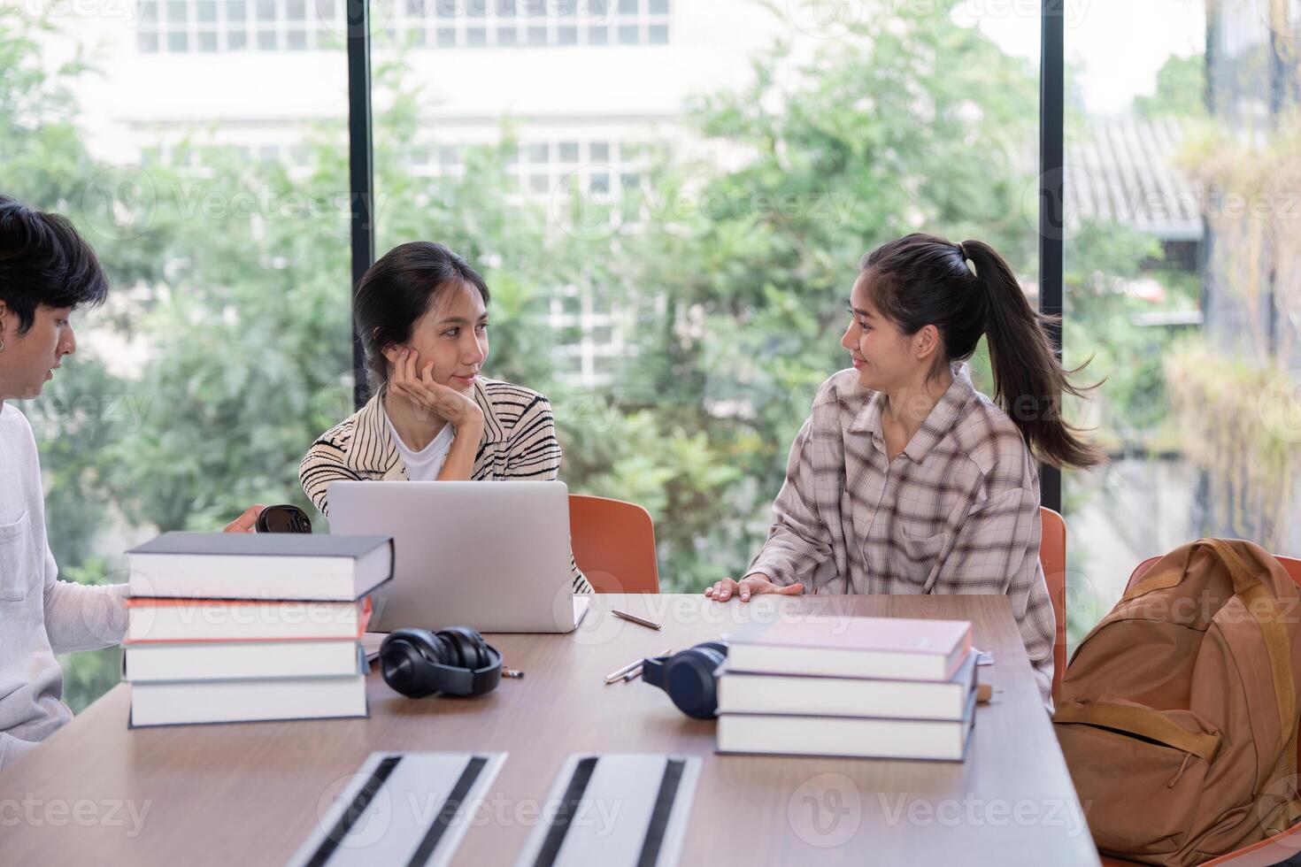 Group of Student Studying Together in a Modern Library with Laptops and Books photo