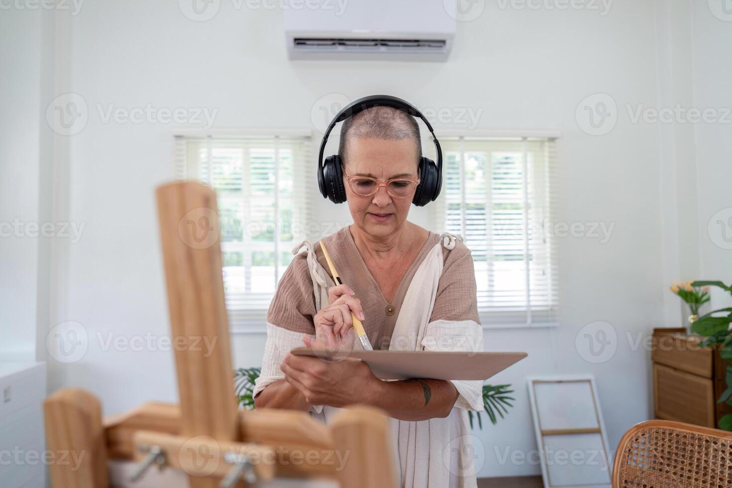Elderly Woman Engaged in Digital Art Creation with Headphones in a Bright Modern Home Studio photo