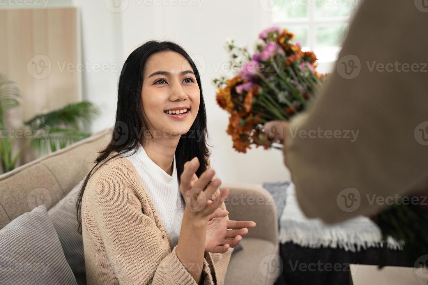 Happy Couple Sharing a Tender Moment with Flowers in a Cozy Modern Living Room photo