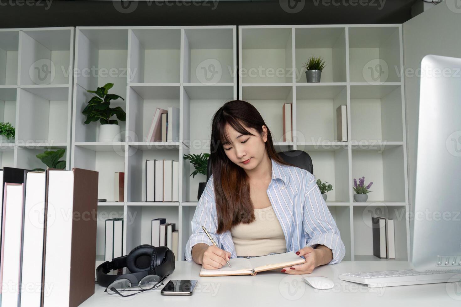 Young Student Studying Online at Home Desk with Books and Computer in Modern Minimalist Workspace photo