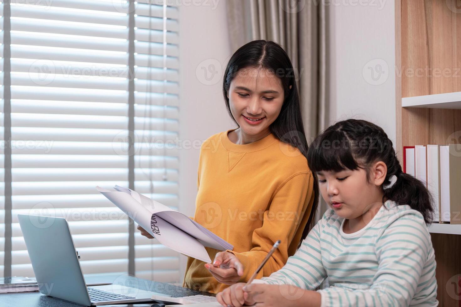 Mother and Child Working from Home Together in a Modern Home Office Setting with Laptop and Documents photo