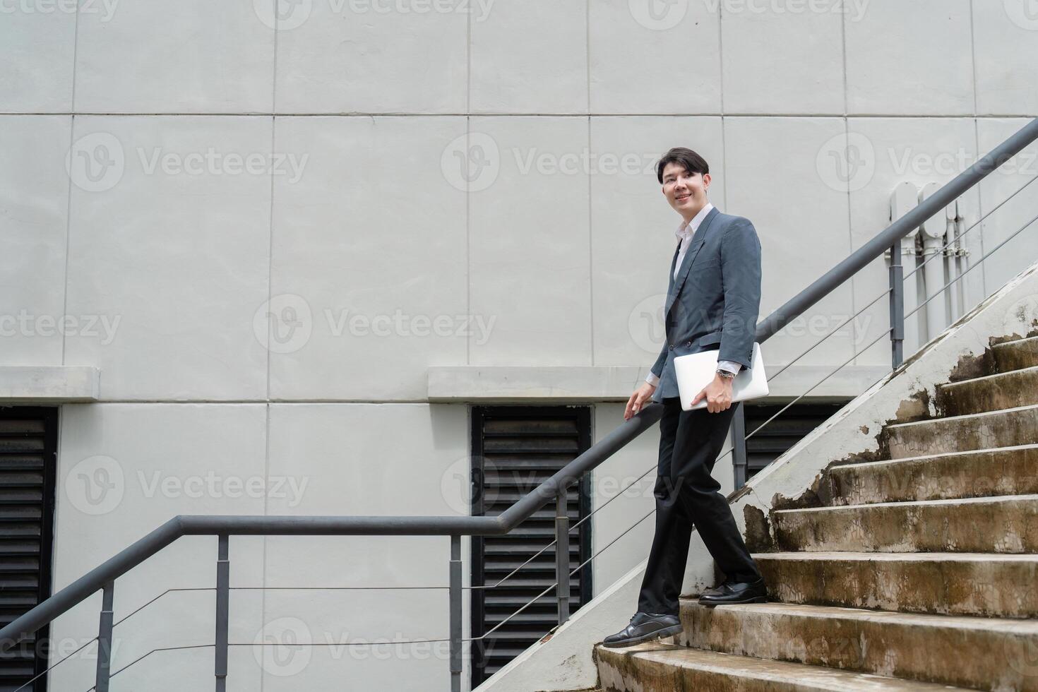 Confident Business Professional Walking Downstairs with Documents in Hand Outside Modern Office Building photo