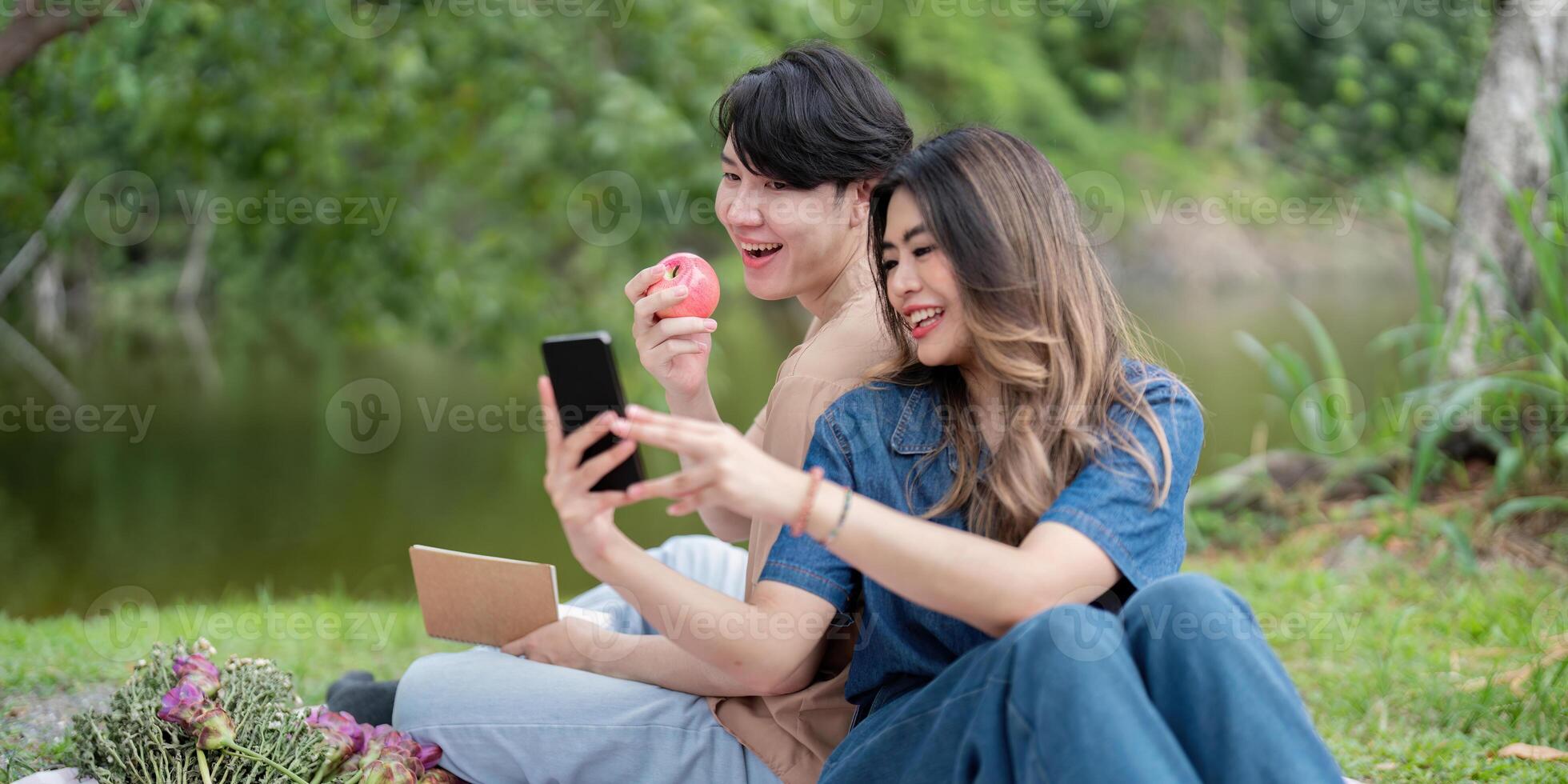 Happy Couple Enjoying a Relaxing Picnic by the Lake in a Beautiful Natural Setting photo