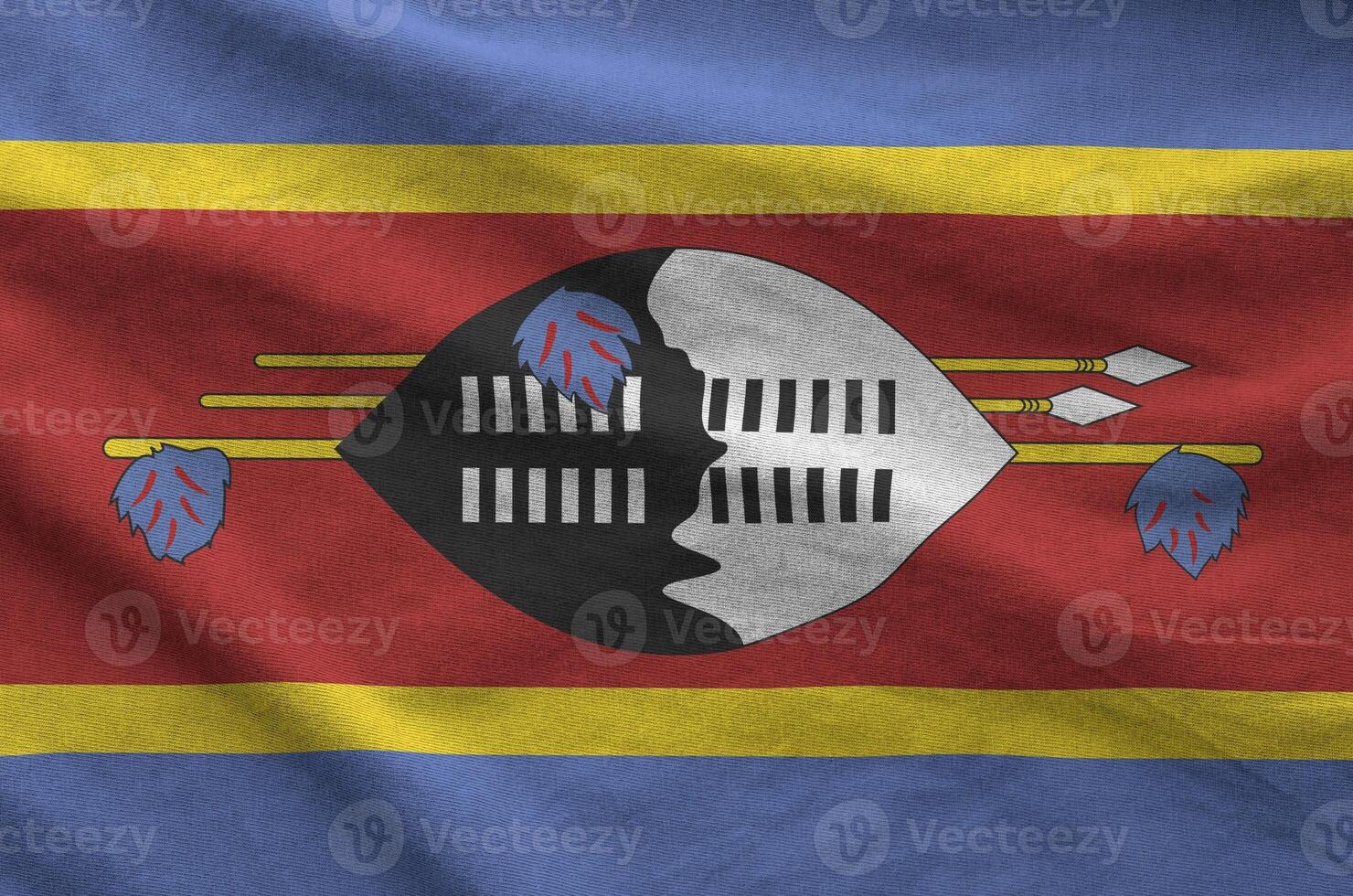 Swaziland flag depicted on folded wavy fabric of old cloth photo