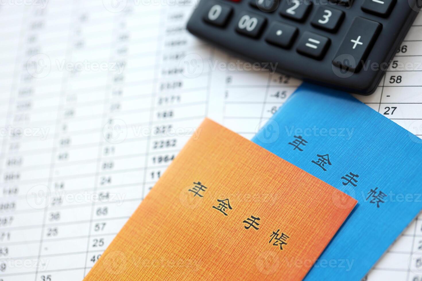 Japanese pension insurance booklets on table with calculator on table photo