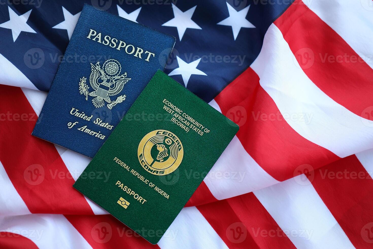 Passport of Nigeria with US Passport on United States of America folded flag photo