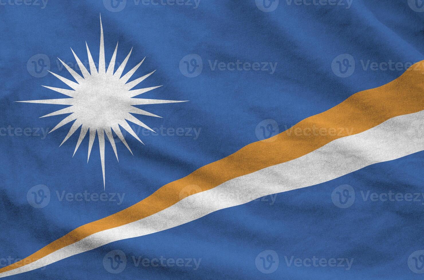 Marshall Islands flag depicted on folded wavy fabric of old cloth photo