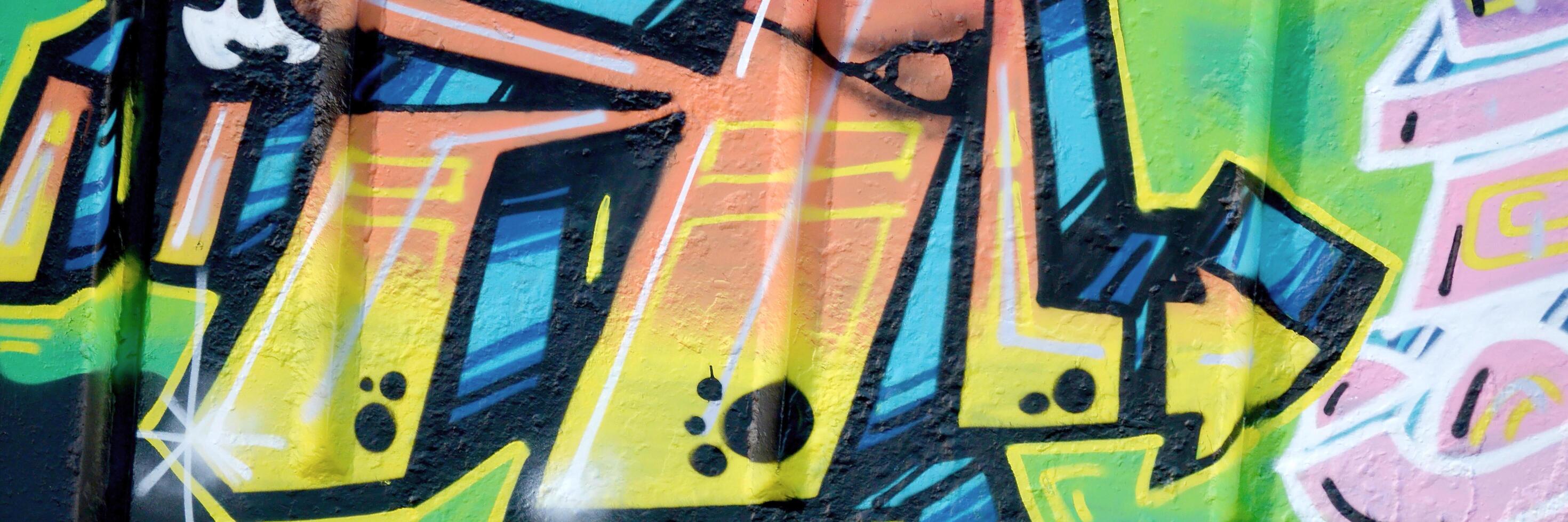 Colorful background of graffiti painting artwork with bright aerosol outlines on wall. Old school street art piece made with aerosol spray paint cans. Contemporary youth culture photo