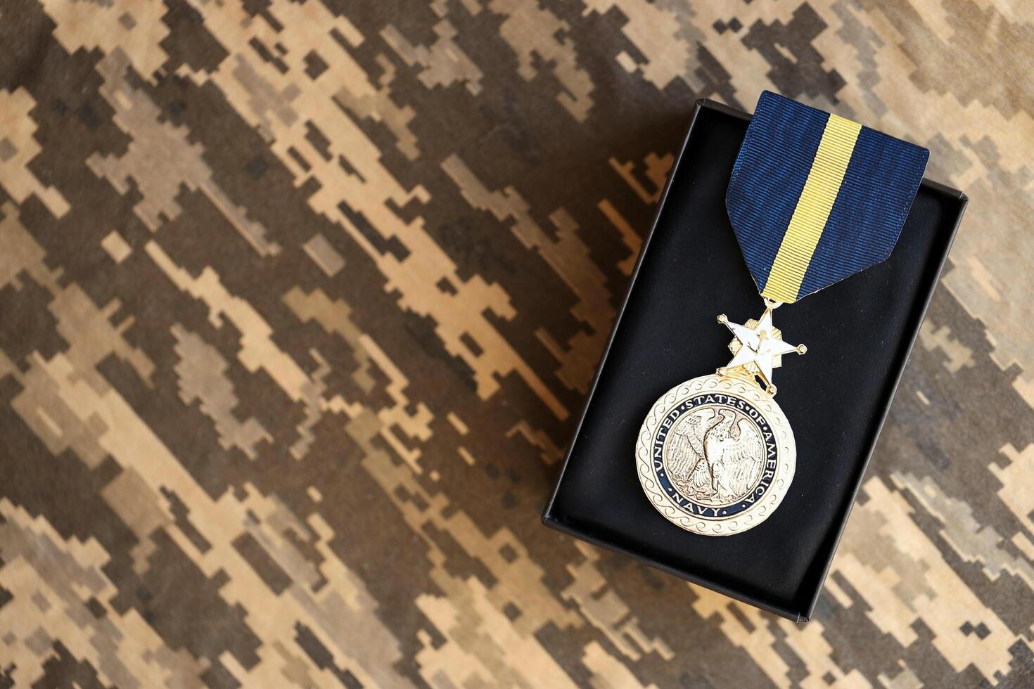 KYIV, UKRAINE - JULY 10, 2024 US Navy Distinguished Service medal. United States military award medal with ribbon and pin. Handmade paper theater props photo